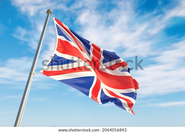 United Kingdom flag waving in\
the wind on flagpole. United Kingdom flag waving a blue cloudy\
sky