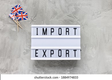 United Kingdom Flags And Text IMPORT EXPORT On Gray Background. Brexit, UK EU Trade Deal, Transition Period, Changes And New Rules Concept. Flat Lay, Copy Space