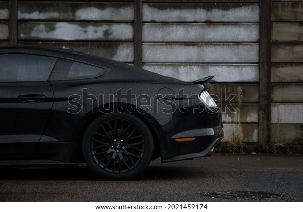 United Kingdom, Manchester April 2021. The Rear Of\
A 2015 Gloss Black Ford Mustang GT With Gloss Black Alloy Wheels On\
An Industrial Estate