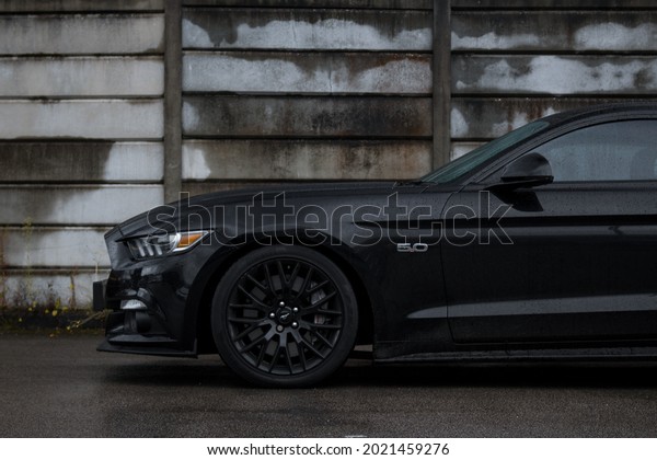 United Kingdom, Manchester April 2021.\
The Front Half Of A 2015 Gloss Black Ford Mustang GT With Gloss\
Black Alloy Wheels On An Industrial\
Estate