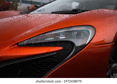 United Kingdom, Manchester May 2021.The Front Xenon Headlight Of A Volcano Orange 2015 McLaren 650S Coupe Supercar