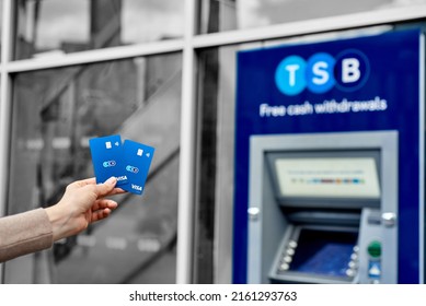 United Kingdom, Newcastle, May 27, 2022: A Woman's Hand Holds A New TSB Bank Card, Against The Background Of An ATM. Bank Card With A Chip And Contactless Payment.