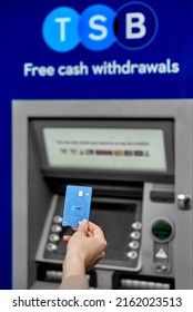 United Kingdom, Newcastle, May 27, 2022: A Woman's Hand Holds A New TSB Bank Card, Against The Background Of An ATM. Bank Card With A Chip And Contactless Payment.