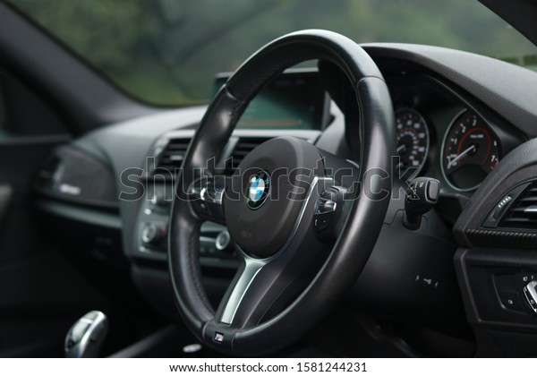 United Kingdom, Newcastle upon\
Tyne December 2019. Close up interior steering wheel and dashboard\
of a  BMW M235i coupe M Performance at an outdoor\
photoshoot.