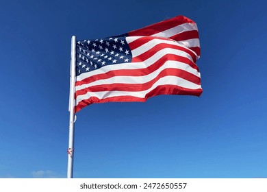 United State of America flag flutters in the wind on blue sky background, Travel and tourism in USA concept, election in USA 2024, closeup