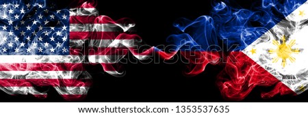 United States of America vs Philippines, Filipino smoky mystic flags placed side by side. Thick colored silky smoke flags of America and Philippines, Filipino.