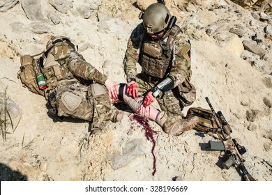 United States Army ranger medic treating the wounds of his injured fellow in arms in the mountains