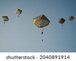 United States Army Soldiers and Paratroopers descending in the sky, from an Air Force C-130 military aircraft during an Airborne Operation.