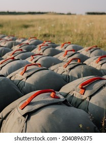 United States Army T-11 Reserve Parachutes Lay On The Ground On A Military Drop Zone In Germany. 