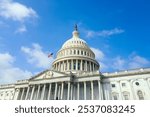 United States Capitol building with American flag over blue sky background, Washington DC