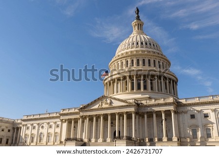 The United States Capitol building with the American flag flying atop its flagpole, Washington DC