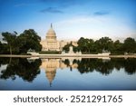 The United States Capitol building reflected on the reflection pool on a sunny day at nation mall, Washington DC, USA.