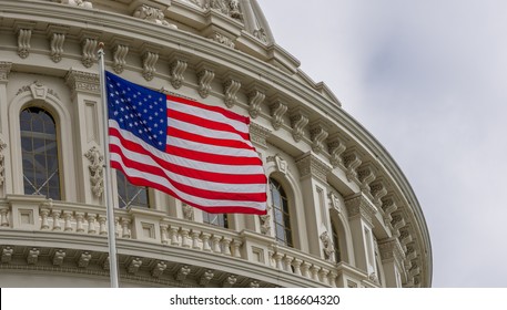 United States Capitol Building With Waving American Flag In Washington DC