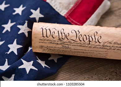 United States Constitution, rolled in a scroll on a vintage American flag and rustic wooden board - Shutterstock ID 1103285504