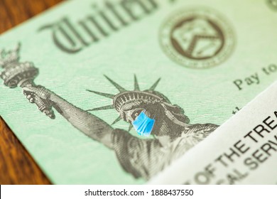 United States IRS Stimulus Check with Statue of Liberty Wearing Medical Face Mask. - Shutterstock ID 1888437550