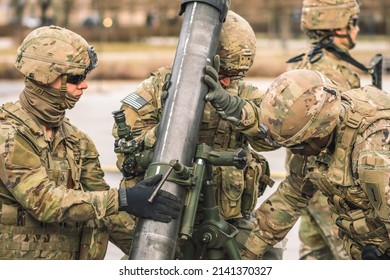 United States - March 29 2022: United States Marine Corps soldiers with helmets and shotguns or rifles preparing a mortar, USA or US army troops ready for battle, drills or war in the city