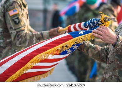 United States - March 29 2022: United States Marine Corps Soldiers Roll Up American Flag During A Ceremony, USA Or US Army Troops Ready For Drills, Battle Or War With Patch On The Uniform