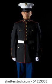 A United States Marine wearing Dress Blues in a studio environment