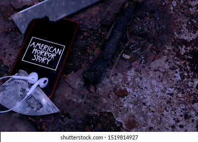 United States New York. Tuesday, October 1, 2019, Headphones And Iphone 11 Pro With The American Horror Story Logo. American Horror Story Is A Drama And Horror Television Series.