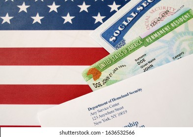 United states permanent resident green card from dv-lottery with social security number lies with USCIS envelope on US flag - Shutterstock ID 1636532566