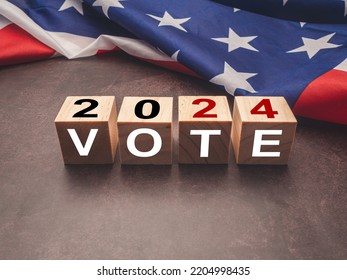 United States presidential election in 2024. Wooden cubes with text VOTE and 2024 over the American flag background. Politics and voting conceptual