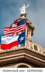 United States and Texas Flags waving in the wind at Austin Texas Capitol Building