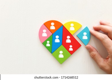 Unity and diversity partnership concept. heart shaped puzzle and group of diverse miniature people connected