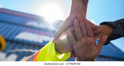 Unity and success concept.Bottom view of Engineer team people standing hands holding together at the container yard.Low Angle View of worker and businessman Team Stacking Hands.Panoramic banner.