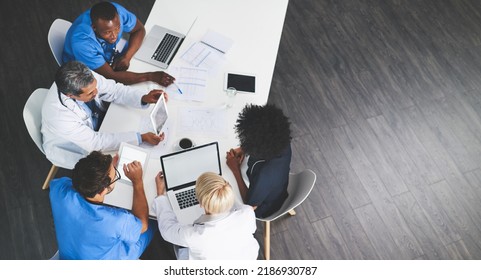 Unity, teamwork and brainstorming by health care workers researching online while having a meeting in conference room. Overhead of doctors browsing the internet to help find cure or medical solution - Powered by Shutterstock