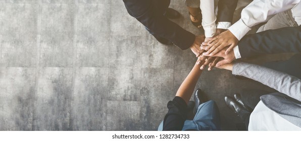 Einheit und Teamwork. Geschäftsleute, die ihre Hände zusammenlegen, Draufsicht, Kopienraum