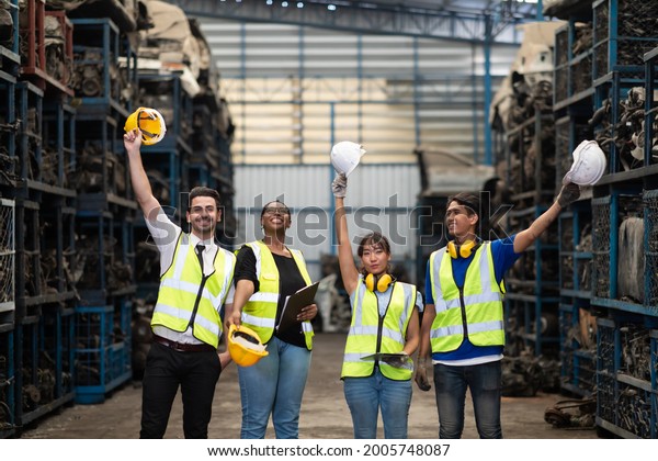 Unity and teamwork\
concept. team standing hands together. Professional Mechanical\
Engineer team Working at Second-hand spare parts of old car parts\
warehouse store. High\
five.
