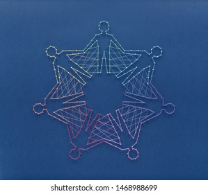 Unity without uniformity and diversity without fragmentation. Network of pins and threads in the shape of people holding hands symbolising community around the world.