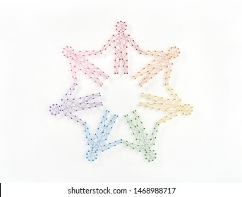 Unity without uniformity and diversity without fragmentation. Network of pins and threads in the shape of people holding hands symbolising community around the world.