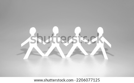 Unity working as a team. Teamwork of colleagues and business partners. Paper doll on gray background. Member support and cooperation.