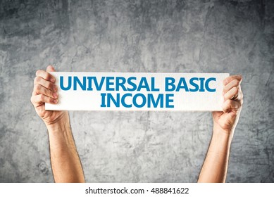 Universal basic income concept with hands holding banner - Shutterstock ID 488841622
