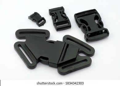 Universal Buckle For Five-point Seat Belts For Strollers, High Chairs. Plastic Hardware For Securing Belts And Shoulder Straps. Black Fastexes, Padlock Retainer On A White Background.