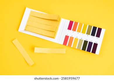 universal indicator paper with acidic testing on yellow background.