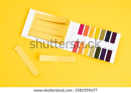 universal indicator paper with acidic testing on yellow background.