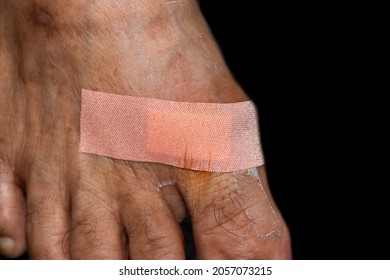 Universal plaster for wound in foot of Asian old woman.