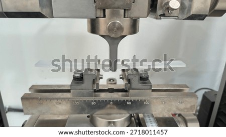 Universal Testing Machine Performing Three-Point Bending Test on Plastic Specimen, Industrial Laboratory Material Strength Analysis, Quality Control and Mechanical Engineering Research Process