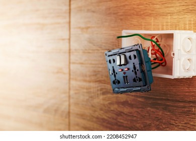 Universal Wall Outlet AC Power Plug With USB Port In A Plastic Box On A Wooden Wall.