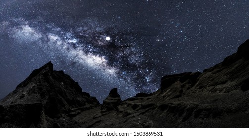 Universe space shot of nebula and milky way on hill under amazing starry blue night sky, large ravine. Silhouette of Snow Mountain Grand Canyon of U Thong Stone Mill Suphanburi, Stonehenge of Thailand - Powered by Shutterstock