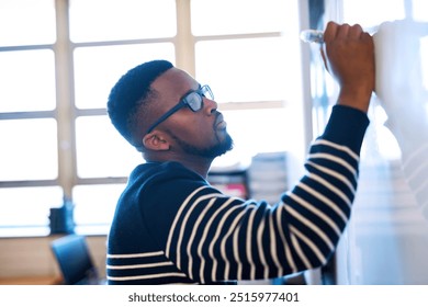 University, classroom and teacher writing on whiteboard for math lesson, learning and examination. Education, teaching and black man write notes for knowledge, assignment and studying in college
