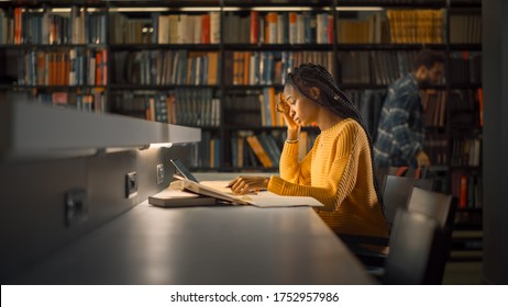 University Library: Gifted Black Girl uses Laptop, Writes Notes for the Paper, Essay, Study for Class Assignment. Students Learning, Studying for Exams College. Side View Portrait with Bookshelves - Shutterstock ID 1752957986