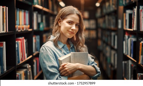 University Library Study: Portrait of a Smart Beautiful Caucasian Girl Holding Study Text Books Smiling Looking at Camera. Authentic Student Does Research for Class Assignment, Exams Preparationtion