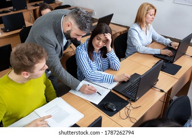 University Professor Lecturing Small Group Of Students In The Classroom