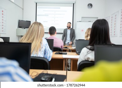 University Professor Lecturing Small Group Of Students In The Classroom