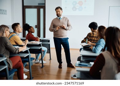 University professor talking to group of students during class in lecture hall. - Powered by Shutterstock