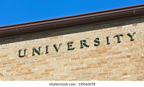 University Sign On A Brick Wall