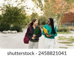 University student girl friends walking after school classes - Asian and African American women